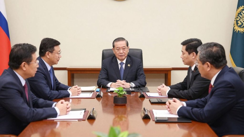 Miniștrii discutând la o masă într-o sală guvernamentală.