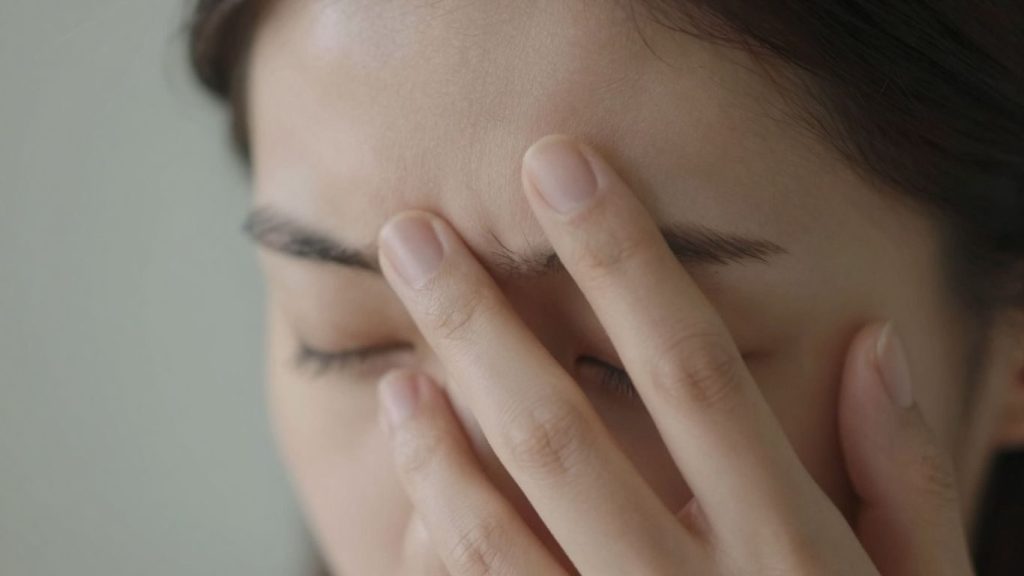 Persoană atingându-și fruntea, semnale subtile ale corpului.