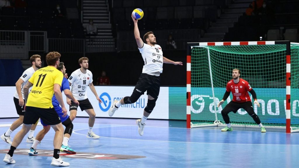 Jucători de handbal în acțiune pe teren.