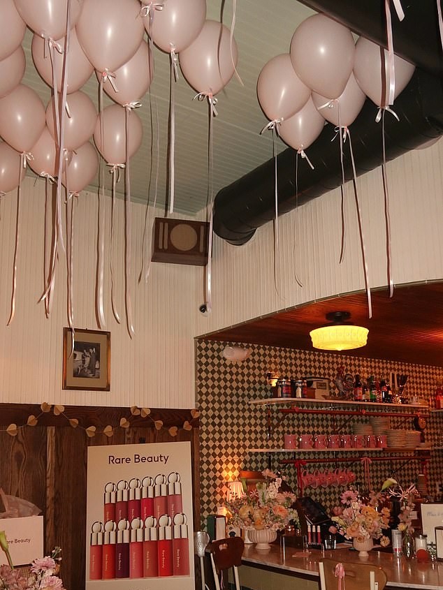 Pastel pink balloons filled the room while bouquets of flowers were placed on tables as well as the diner bar top