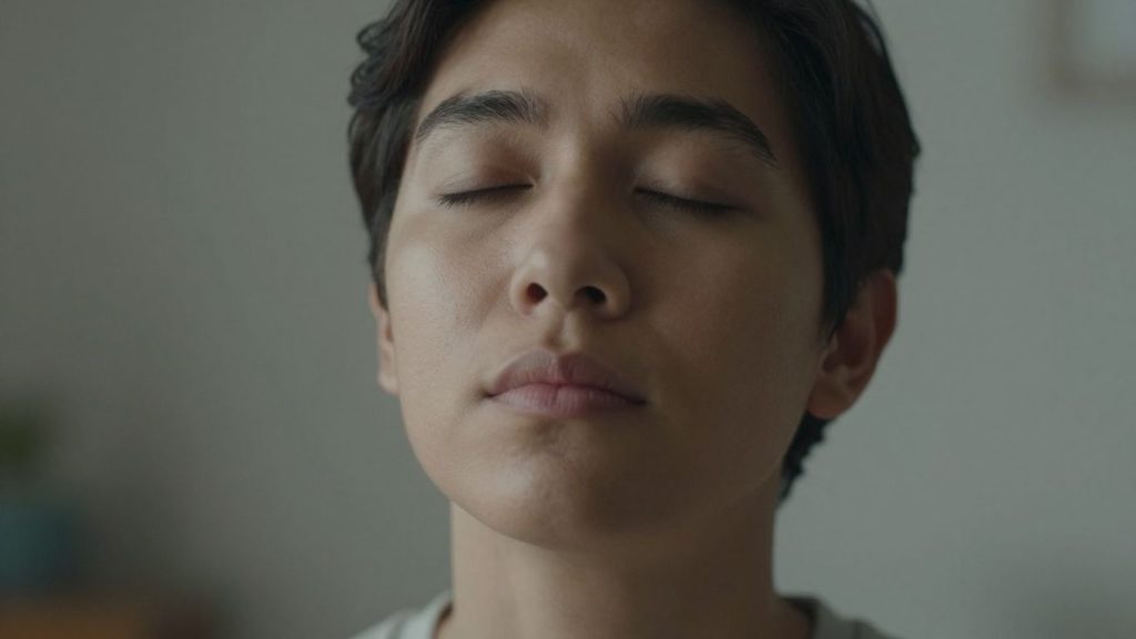 Persoană calmă respirând adânc în situație tensionată.