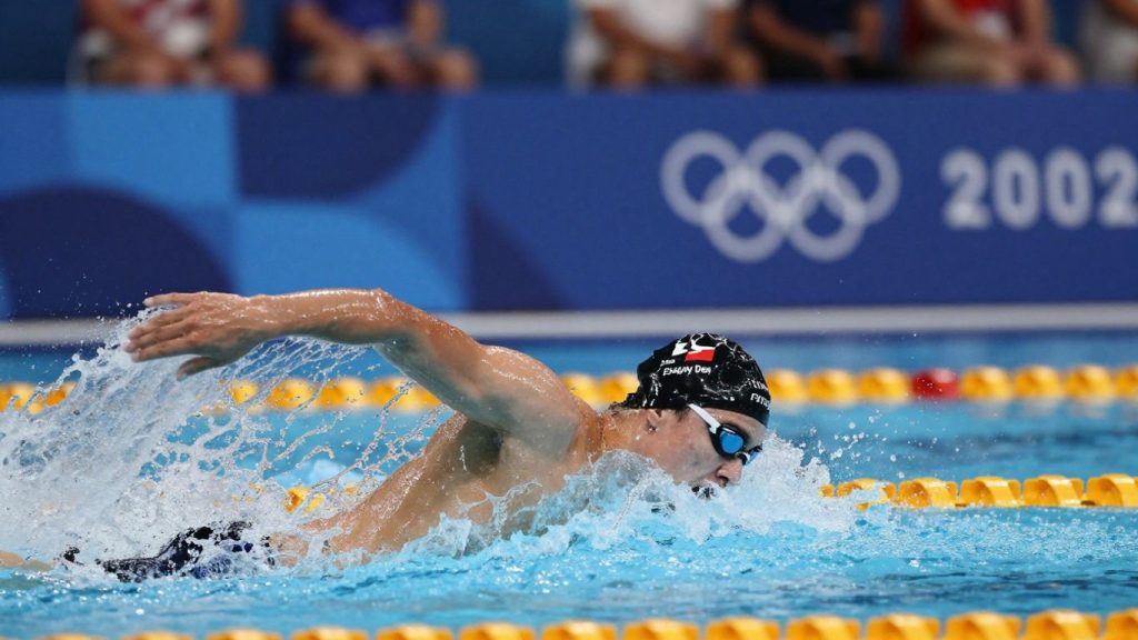 Înotători olimpici în acțiune, cu stropi de apă.